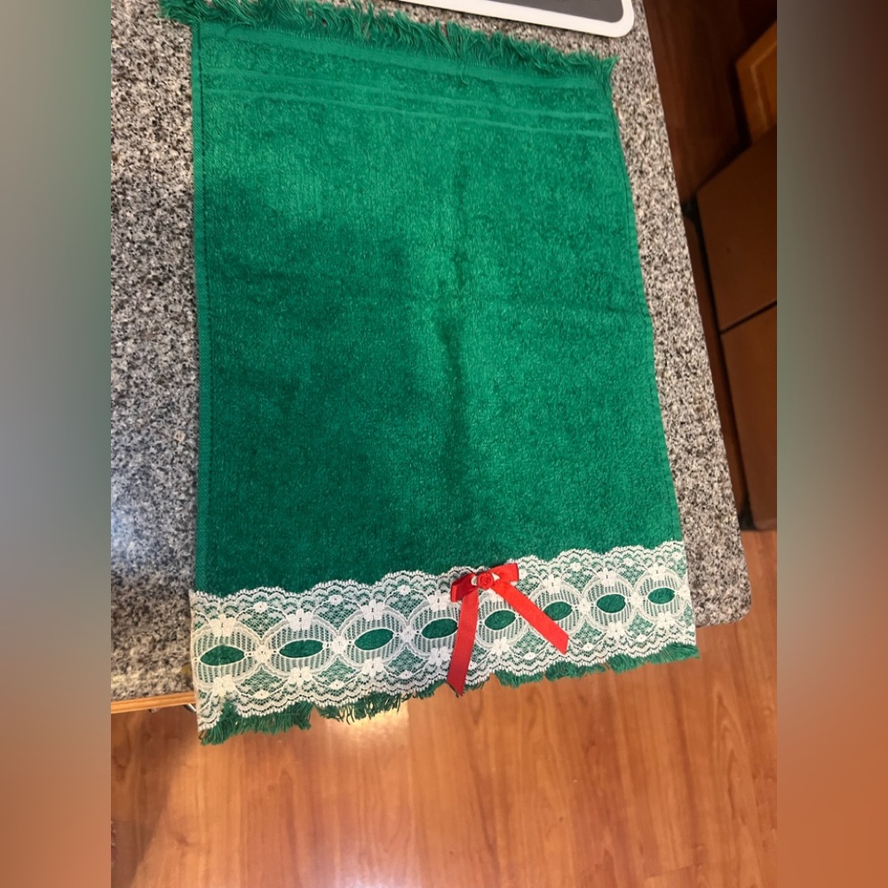 Green vintage towel with white lace and red bow detail